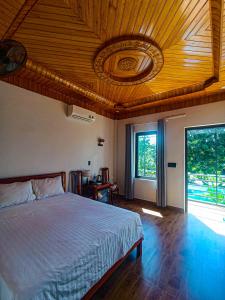 a bedroom with a bed with a wooden ceiling at YoLo Pool Bar Villas in Phong Nha