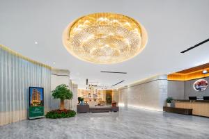 a lobby with a large chandelier in a building at Shanshui Trends Hotel - Shatian Metro Station Longguang City in Huizhou