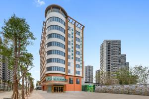 an apartment building in a city with tall buildings at Shanshui Trends Hotel - Shatian Metro Station Longguang City in Huizhou