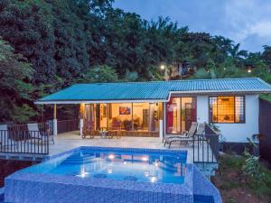 una casa con piscina frente a una casa en Alta Vista Villas Vacation Rentals, en Manuel Antonio
