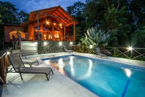 a swimming pool in front of a house at Alta Vista Villas Vacation Rentals in Manuel Antonio