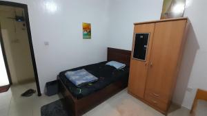 um pequeno quarto com uma cama e um armário em Adbldna01 em Abu Dhabi