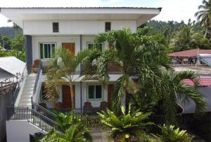 a white house with palm trees in front of it at Casa Santuaria in Itaytay