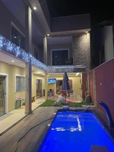 a swimming pool in the middle of a house at night at Casa de férias ventilada com 4 quartos à 5 min da praia in Salinópolis