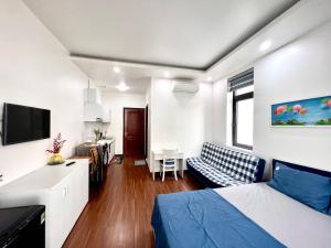 a bedroom with a bed and a living room at Daisy homestay & apartment in Hai Phong