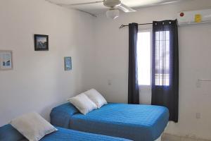 1 dormitorio con 2 camas individuales y ventana en CASA CHACHALACAS, en Chachalacas