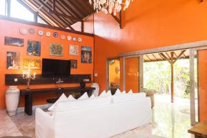 a living room with orange walls and a white couch at Ocean Star Villa Five near the KuDeTa Beach in Seminyak