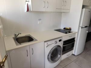 a kitchen with a sink and a washing machine at Deluxe Studio - Unit 12 in Emu Park