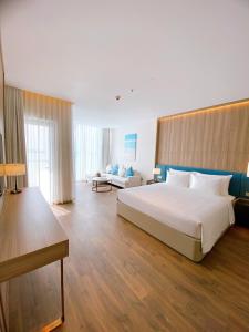 um quarto grande com uma cama grande e um sofá em Khách sạn A La Carte Hạ Long-Quảng Ninh em Ha Long