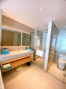 uma casa de banho com um lavatório e um chuveiro em Khách sạn A La Carte Hạ Long-Quảng Ninh em Ha Long