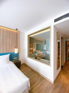 um quarto com uma cama branca e uma grande janela em Khách sạn A La Carte Hạ Long-Quảng Ninh em Ha Long