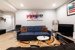 a living room with a blue couch and a tv at Little Persian Palace with Parking in Washington, D.C.