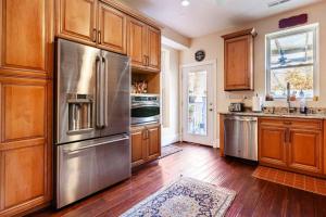 a kitchen with wooden cabinets and a stainless steel refrigerator at Little Persian Palace with Parking in Washington