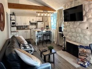 uma sala de estar com um sofá e uma cozinha em Le1601 - Le Petit Renard - Chalet spa et plage em Sainte-Lucie-de-Doncaster