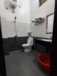 a bathroom with a toilet and a sink at ĐỒNG TÂM HOTEL in Bắc Yên