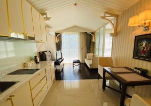a kitchen and living room with a couch and a table at Pattaya Grand florida Beach 36 in Na Jomtien