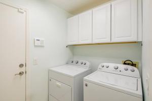 a kitchen with white cabinets and a washer and dryer at Sin City's Hidden Gems in Las Vegas