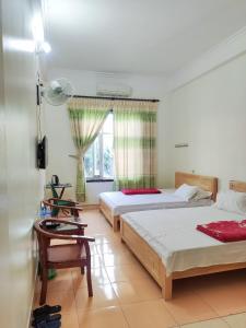 a bedroom with two beds and a window at ĐỒNG TÂM HOTEL in Bắc Yên