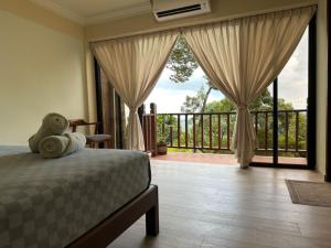 een slaapkamer met een bed en uitzicht op een balkon bij Bao Sheng Durian Farm in Balik Pulau