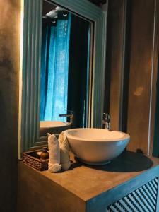 a bathroom with a bowl sink and a mirror at Jansen’s Bungalow Sinharaja Rainforest Retreat in Kudawe