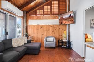 a living room with a couch and a chair at Beachfront Holiday House in Zilzie