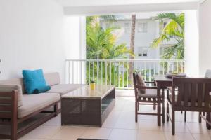una sala de estar con un sofá y una mesa en Azure Harmony - A Breezy Hideaway at The Beach Club, en Palm Cove