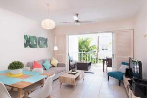 una sala de estar con un sofá y una mesa en Azure Harmony - A Breezy Hideaway at The Beach Club, en Palm Cove