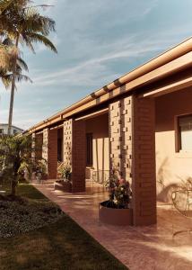 ein Gebäude mit einer Terrasse mit Palmen und Pflanzen in der Unterkunft Swell Hotel Byron Bay - Adults Only in Byron Bay
