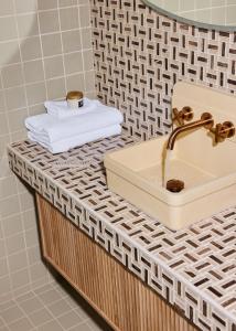 Swell Hotel Byron Bay - Adults Only في خليج بايرون: منضدة الحمام مع الحوض والمنشفة