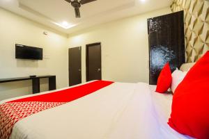 a bedroom with a large white bed with red pillows at OYO Hotel Sonali in Nagpur