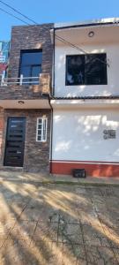 a house on a street with a building at Departamento Glorieta in Mazamitla