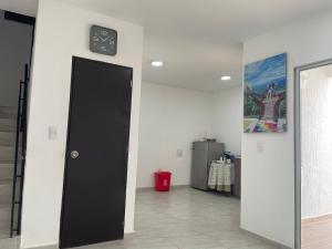 una habitación con una puerta negra y un reloj en la pared en Alojamiento en Neiva en Santa Rosalía de Guagua