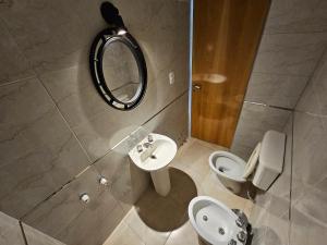 a bathroom with a sink and a toilet and a mirror at Departamento Pbaja centro Mendoza in Las Heras
