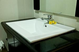 a bathroom sink with a yellow flower on it at Jepun Bali Hotel in Kuta