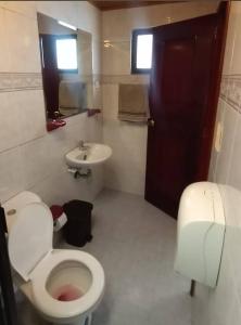 y baño con aseo y lavamanos. en Hotel Habitat Hospedaje, en Bogotá