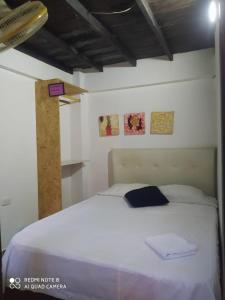 una camera da letto con un letto bianco in una stanza di Casa Turistica Zamboss a Montería