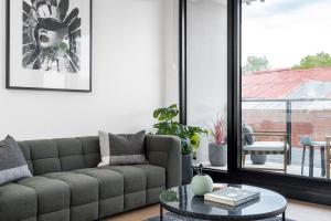 uma sala de estar com um sofá e uma mesa em Boutique Stays - Axel Apartments G02 The Faircroft em Melbourne