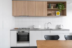 uma cozinha com um fogão e uma bancada em Boutique Stays - Axel Apartments G02 The Faircroft em Melbourne