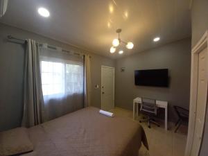 Dormitorio con cama, escritorio y TV en Palmerola Inn, en Comayagua