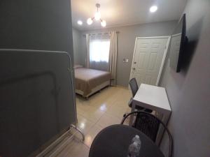 Habitación pequeña con 1 dormitorio con cama y mesa. en Palmerola Inn, en Comayagua