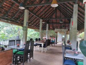 ein Esszimmer mit Tischen und Stühlen in einem Gebäude in der Unterkunft Jansen’s Bungalow Sinharaja Rainforest Retreat in Kudawe