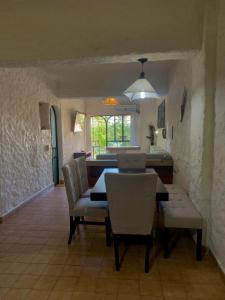 a dining room with a table and chairs and a kitchen at De Vacaciones in Zihuatanejo