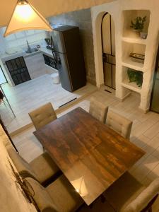 een keuken met een houten tafel en een koelkast bij De Vacaciones in Zihuatanejo