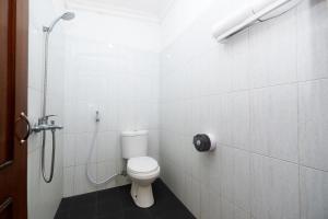 bagno bianco con servizi igienici e doccia di Perdana Kasih Hotel Klaten a Solo