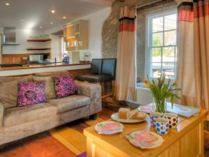 a living room with a couch and a table at Rhosson Chapel Cottage in St. Davids