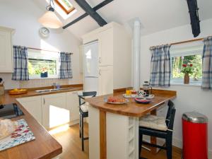 uma cozinha com uma mesa de madeira e uma bancada em Llys Isaf em Saint Nicholas