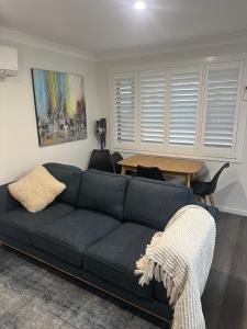 a living room with a blue couch and a table at Central Evans Wagga Apartments in Wagga Wagga