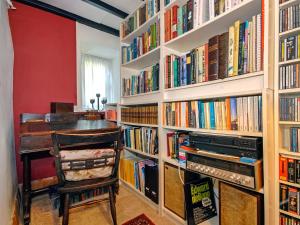 a library with a desk and a chair and books at Llys Isaf in Saint Nicholas