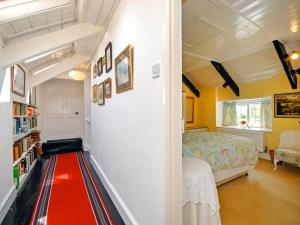 a bedroom with a red carpet in the hallway at Llys Isaf in Saint Nicholas