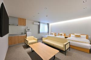 ein Hotelzimmer mit 2 Betten und einem Tisch in der Unterkunft GRAND BASE Hiroshima Peace Memorial Park in Hiroshima